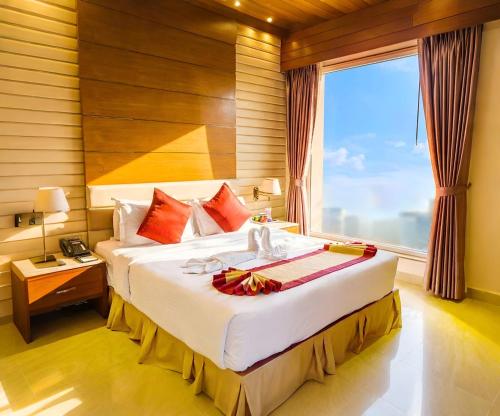 a bedroom with a large bed with a large window at FARS Hotel & Resorts - BAR-Buffet-Pool-SPA in Dhaka