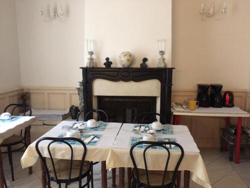 a dining room with two tables and a fireplace at Hotel Acapulco in Montpellier