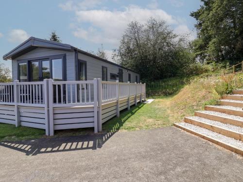 a tiny house with a white fence and stairs at The Pines 3 Bedrooms in Northwich