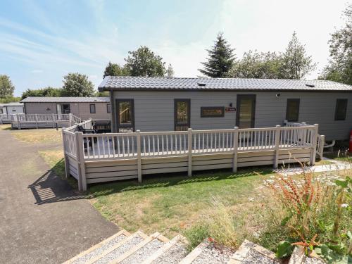a house with a fence in front of it at The Pines 3 Bedrooms in Northwich