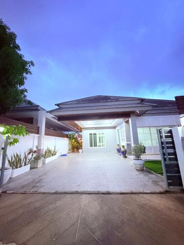 a large white house with a large patio at Swansea Villa 3 BR in Ban Huai Yai