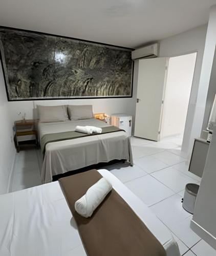 a bedroom with two beds and a couch in it at Abaíra Serra Azul Lofts 1 - Orla - Centro in Petrolina
