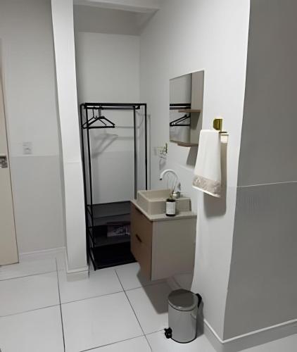 a white bathroom with a sink and a mirror at Abaíra Serra Azul Lofts 1 - Orla - Centro in Petrolina