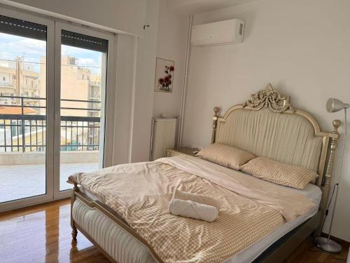 a bed in a bedroom with a large window at Piraeus new hotel in Piraeus