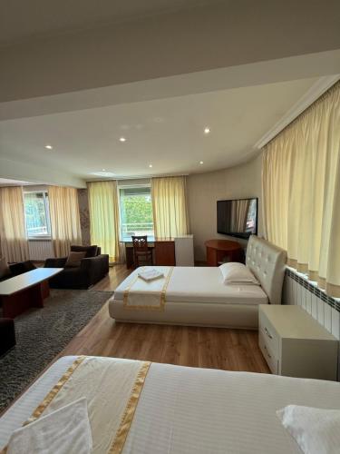 a bedroom with a large bed and a living room at Motel Eros in Sandanski