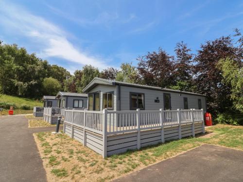 a tiny house with a white fence at The Oaks 3 Bedrooms in Northwich