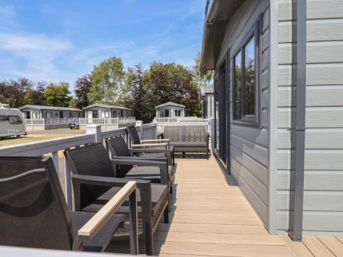 a deck with chairs and windows on a building at The Oaks 2 Bedrooms in Northwich