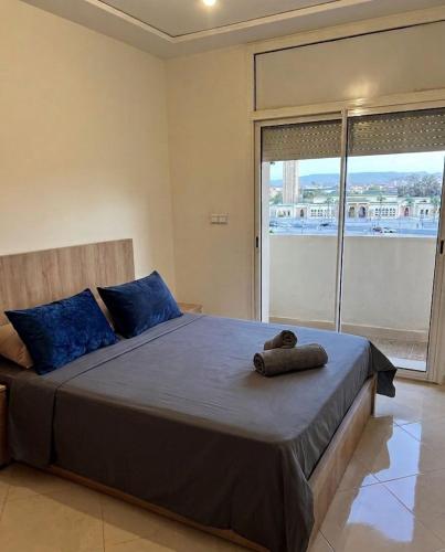 a bedroom with a bed with a teddy bear laying on it at Luxury Apartment Elevator FIBER WIFI in Oujda