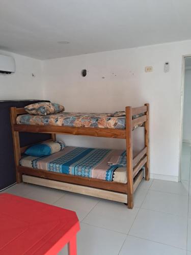 two bunk beds in a room with a red table at Cabañas Calipso # 7 in Coveñas