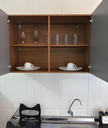 a kitchen with a counter with plates and a sink at Abaíra Serra Azul Loft 5 - Orla - Centro in Petrolina