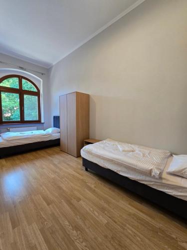 a bedroom with two beds and a large window at Willa Carcassonne in Paczków