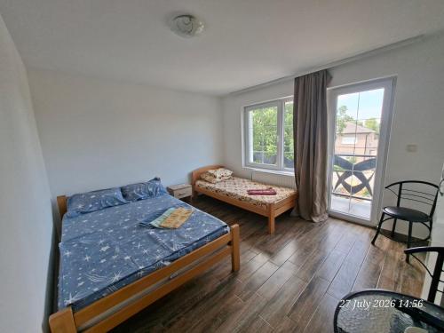 a bedroom with a bed and a chair and a window at EasyHedonist in Stara Pazova