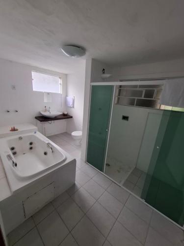 a bathroom with a tub and a shower and a sink at Casazul in Lavrinhas