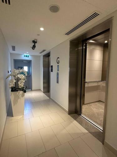 a hallway of a building with a elevator and a door at Waterfront Yas 1BR near F1 & Ticket Savings in Abu Dhabi