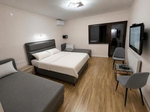 a bedroom with two beds and a flat screen tv at Hidden Hills Cottage Sarajevo in Sarajevo