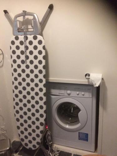a washing machine in a bathroom with a polka dot curtain at B&B In de Oude Smederij Zaltbommel in Zaltbommel