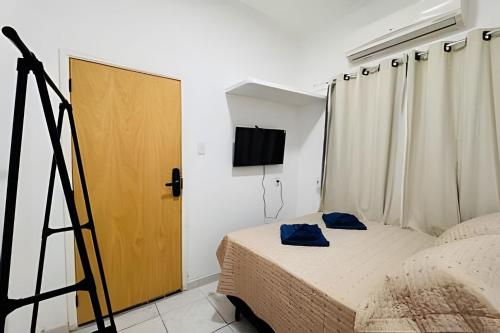 a small bedroom with a bed and a television at Abaíra Serra Azul Suítes 03 - Centro in Petrolina