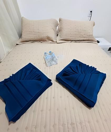 a bed with blue sheets and pillows on it at Abaíra Serra Azul Suítes 01 - Centro in Petrolina