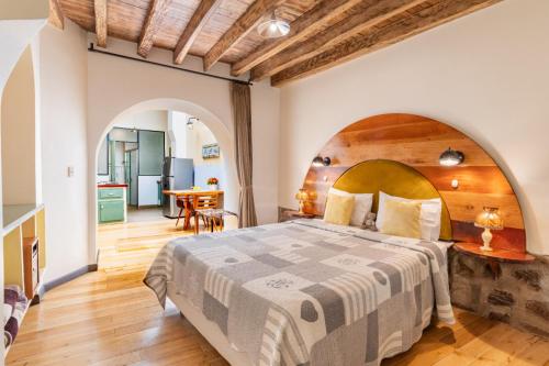 a bedroom with a large bed with a wooden headboard at The Secret Garden in Quito