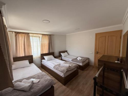 a room with two beds and a table at Tebdi Qor, Warm Home in Mestia