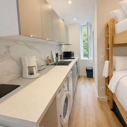 a kitchen with a washer and dryer next to a bed at Wapiti apartment in Loctudy