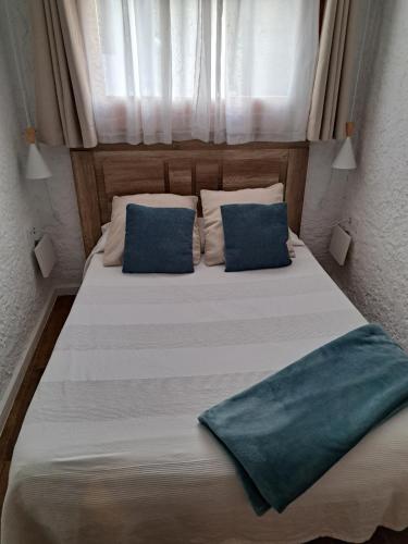 a large bed with two blue pillows on it at Can Teixidor in Besalú