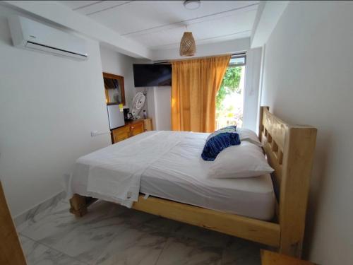 a bedroom with a large bed with a window at Hostel Rincon del mar Ebenezer in San Onofre