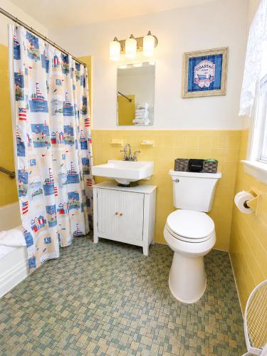a bathroom with a toilet and a sink at A Beach Breeze Inn in West Harwich