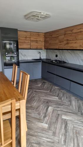 a kitchen with a wooden table and a table and chairs at Гостинний дім in Shom