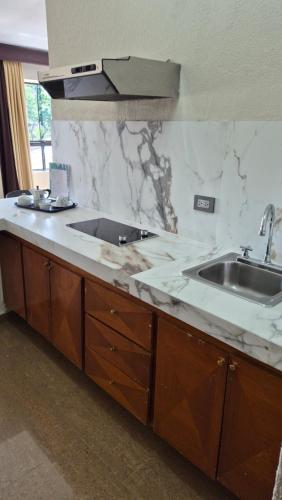 a kitchen with a sink and a counter top at Hotel Emperador VENEZUELA in Valencia