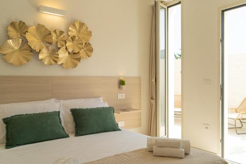 a bedroom with a bed with green pillows and mirrors at Viver Guest House in La Caletta