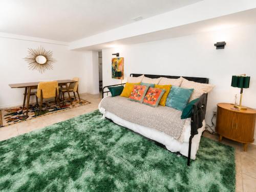 a living room with a bed and a green rug at The Nest in Fort Collins