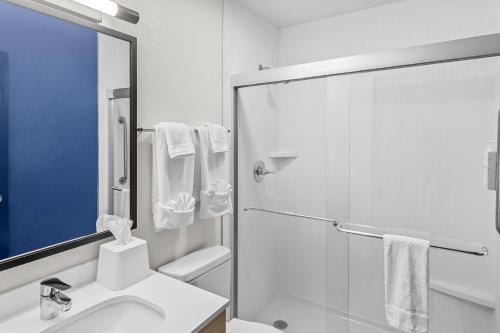 a white bathroom with a shower and a sink at Spark By Hilton Prestonsburg in Prestonsburg