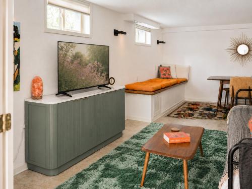 a living room with a flat screen tv on a cabinet at The Nest in Fort Collins