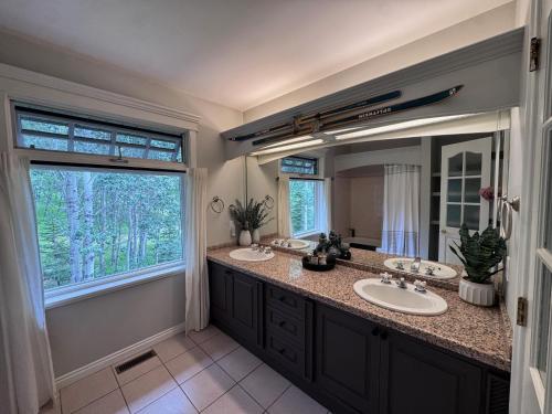 a bathroom with two sinks and a large mirror at The Wandering Antler - Bragg Creek in Bragg Creek