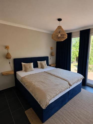 a bedroom with a large bed with a blue headboard at Lavendelhaus am Müritzsee - direkt am Wasser in Buchholz
