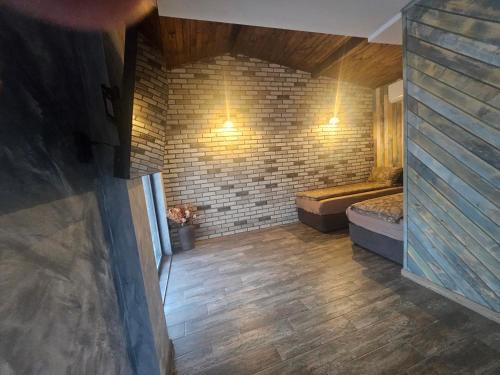 a room with two beds and a brick wall at Къща за гости Жеглица in Zheglitsa