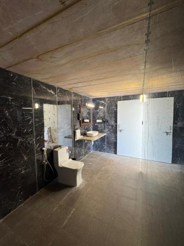 a bathroom with a toilet and a sink at Mahindra Desert Resort & Camp in Jaisalmer