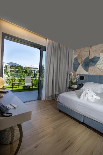 a bedroom with a bed and a desk and a balcony at Continental Golf Resort in Verbania
