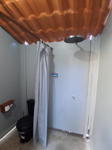 a bathroom with a toilet and a shower curtain at Garden House - Atins in Atins
