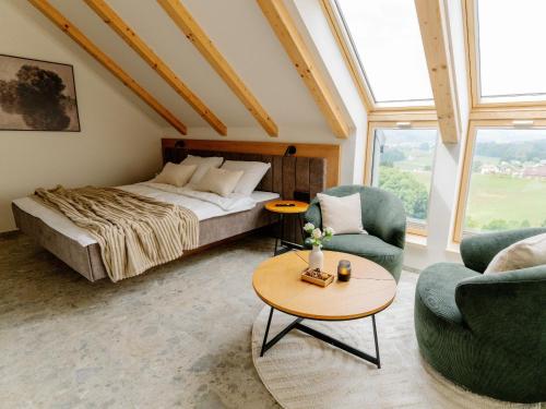 a bedroom with a bed and two chairs and a table at Brioni Hills - Premium Escape in Šmarje pri Jelšah