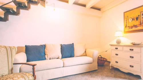 a living room with a white couch and a dresser at Chibedda Dimora Lia in Acitrezza