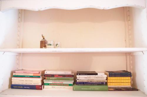 a stack of books on a shelf at Chibedda Dimora Lia in Acitrezza