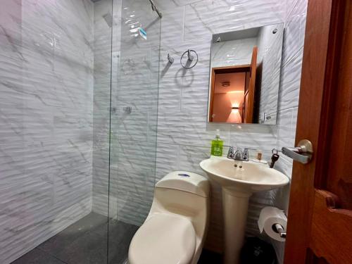 ein Badezimmer mit Dusche, Toilette und Waschbecken in der Unterkunft Los Barranqueros Hotel in Salento