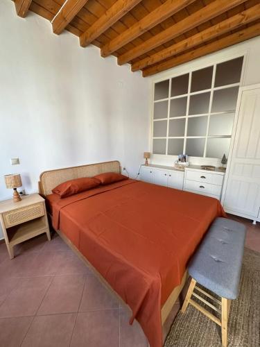 a bedroom with a large bed and a chair at Marea Patmos in Skala