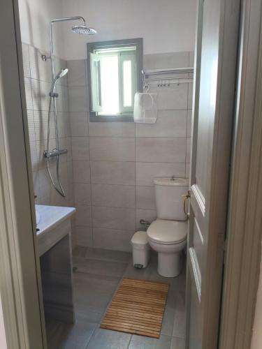 a bathroom with a toilet and a sink and a window at Marea Patmos in Skala