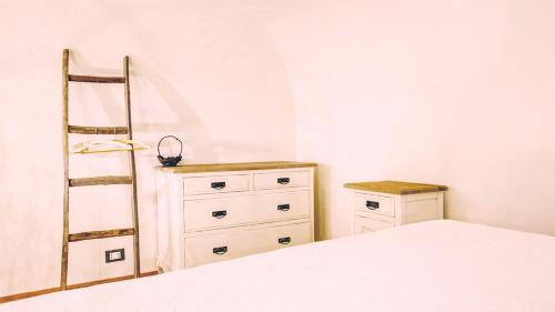 a bedroom with a bed and a ladder and a dresser at Chibedda Dimora Lia in Acitrezza