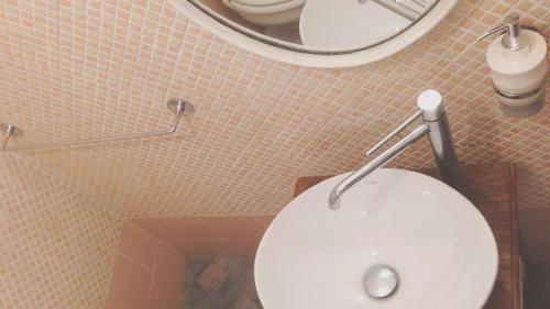 a bathroom with a white toilet and a mirror at Chibedda Dimora Lia in Acitrezza