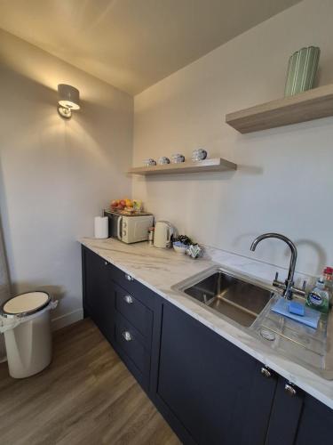 a kitchen with a sink and a counter top at Clarke Cottage Guest House in Dunfermline