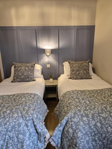 two beds sitting next to each other in a room at Clarke Cottage Guest House in Dunfermline
